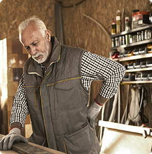 older man working at his shop has lower back pain