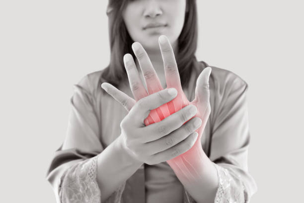 Asian woman suffering from pain in bone against gray background, Concept with hand arthritis grimace in pain