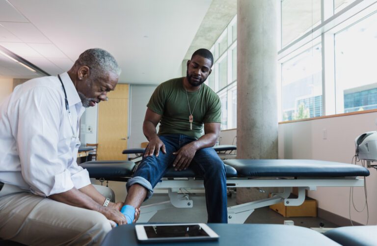 Orthopedic doctor examines injured soldier's ankle