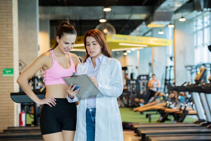 Sports medicine physician shows instructions to a woman athlete