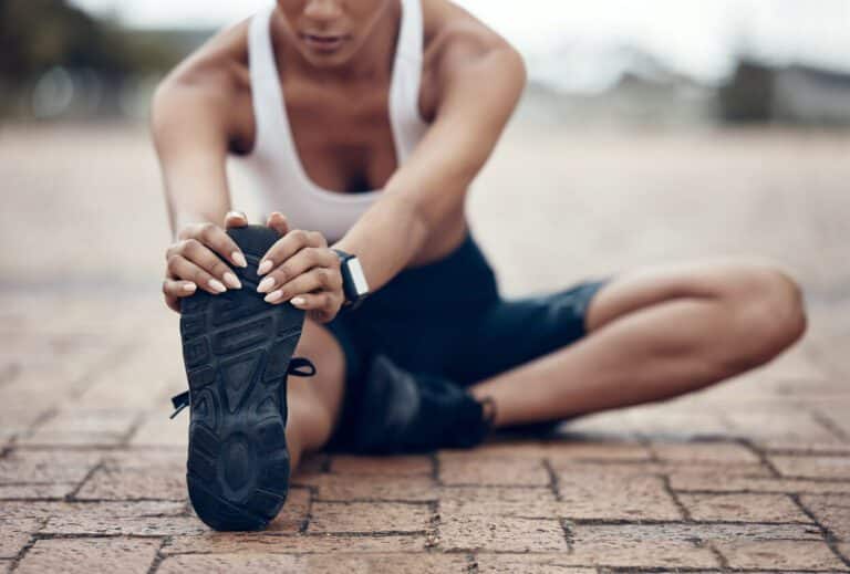 Woman stretching prior to completing fitness exercise to prevent injury.