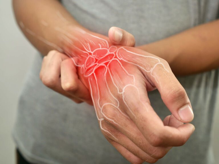 A person is touching their wrist in response to pain caused by aching wrist pain.A person is touching their wrist in response to pain caused by aching wrist pain.A person is touching their wrist in response to pain caused by aching wrist pain.