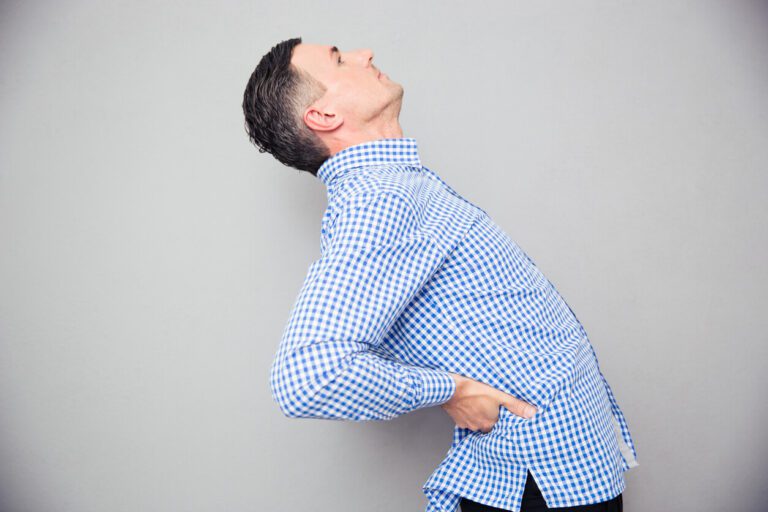 Man having a back pain caused by his spinal stenosis condition.