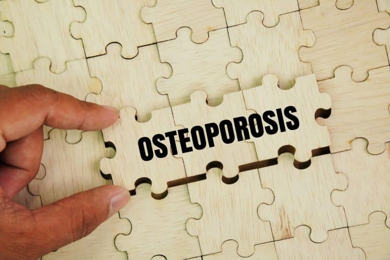 Wooden puzzle with words Osteoporosis is a type of bone disease characterized by reduced bone mineral density