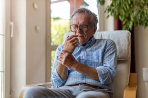 Senior man sitting in a chair with wrist pain
