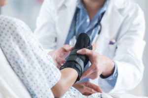 A person getting her wrist sprain wrapped up by a physician.