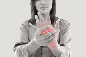 Asian woman suffering from pain in bone against gray background, Concept with hand arthritis grimace in pain