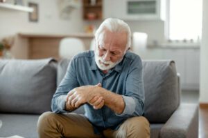 Elderly male patient suffer from numbing pain in hand,numbness fingertip,arthritis inflammation,beriberi or peripheral neuropathies,senior man massage his hand with wrist pain,rheumatoid arthritis