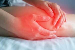 Knee pain disease concept. Hands on leg as hurt from bursitis