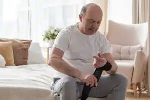 Roll of bandage for stretched the wrist for pain release. Senior man bandaging his trauma.