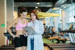 Sports medicine physician shows instructions to a woman athlete