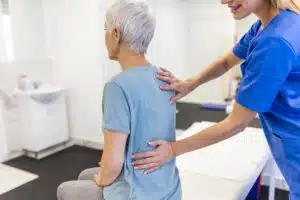 Senior woman having physical therapy for back pain discomfort