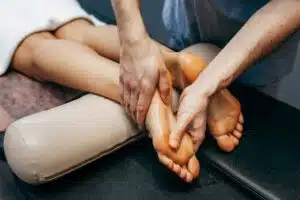 The podiatrist examines and massages the patient's foot with plantar fasciitis at the clinic.