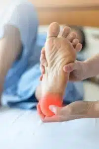 A foot and ankle surgeon is holding a patient's leg during treatment for heel spurs.