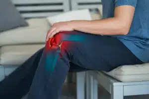 Knee pain, man suffering from knee bursitis at home.