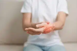 Woman having wrist pain while sitting on sofa at home.