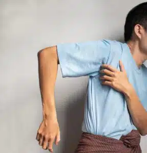 Stiffness in the shoulder joint of an asian man which can be frozen shoulder problems.