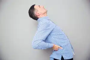 Man having a back pain caused by his spinal stenosis condition.