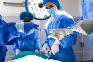 Hand surgeons hands in sterile gloves passing surgical instruments over patient.